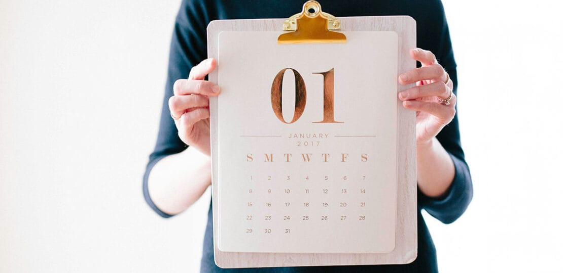 mulher segurando um calendário em um fundo branco